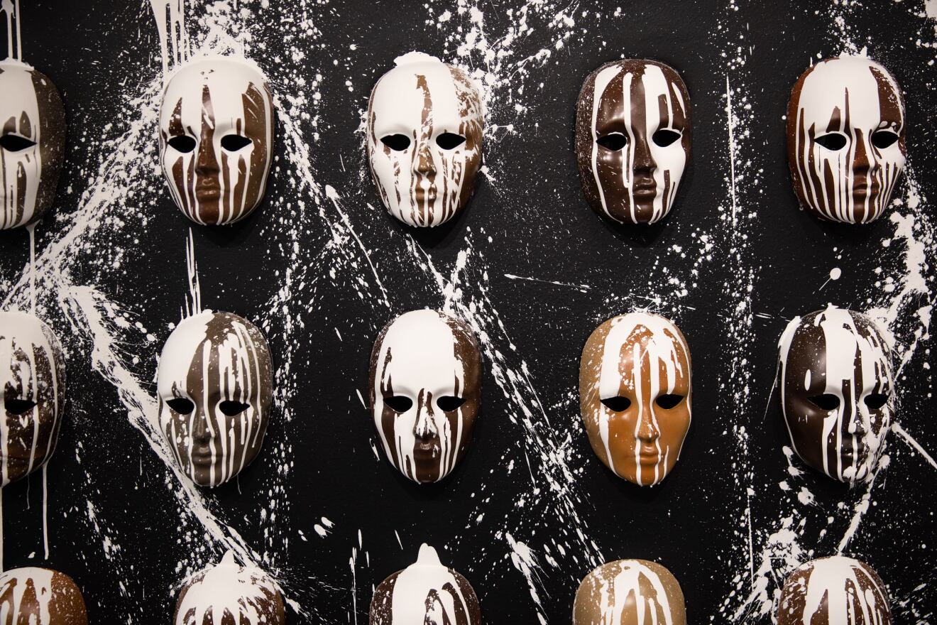 An array of masks is displayed for the Be Nice (White) You're In Bend exhibit at Scalehouse in Bend, Ore., Friday, Aug. 6, 2021. The masks symbolize how many Black, Indigenous and people of color feel they must mask who they really are in uber-white Bend.